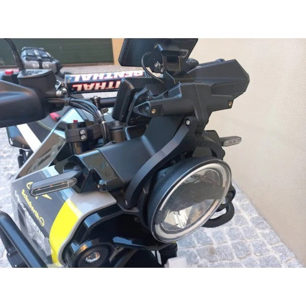 Moto Explorer black RideTrak navigation stabiliser mounted on a Husqvarna Norden 901 motorcycle headlight assembly.